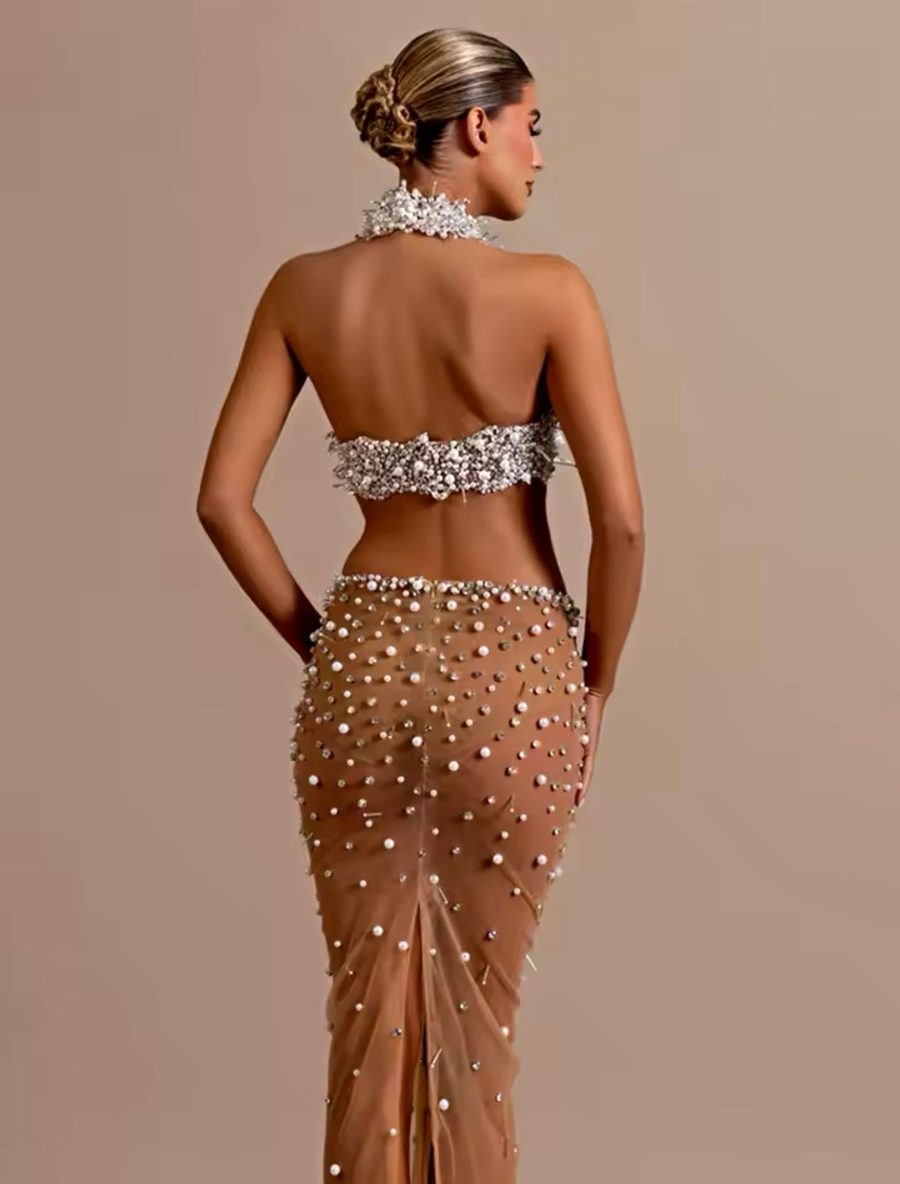 Set of top and skirt, delicately embroidered with shiny stones and pearls, creating a sophisticated design. Perfect to show off a glamorous and sophisticated look on any special occasion.