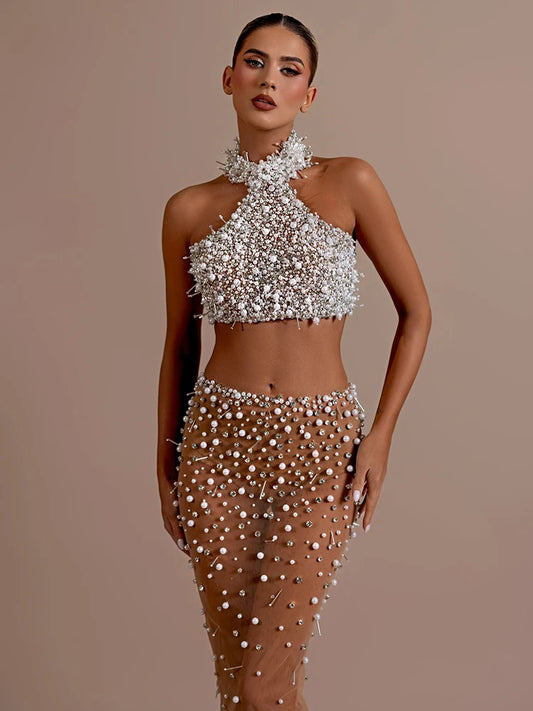 Set of top and skirt, delicately embroidered with shiny stones and pearls, creating a sophisticated design. Perfect to show off a glamorous and sophisticated look on any special occasion.